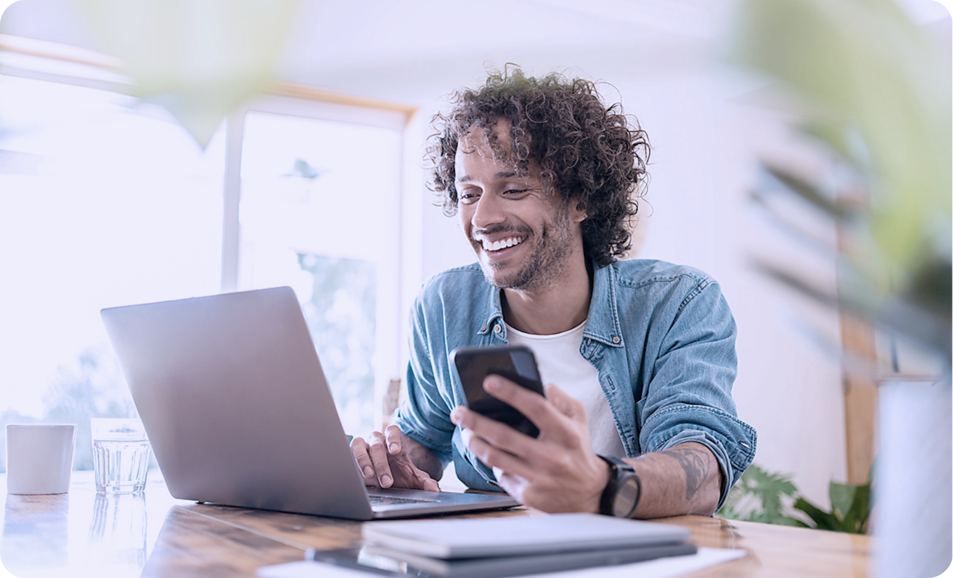 Flexibles Lernen mit modernen LMS Funktionen: Mitarbeiter nutzt parallel Laptop und Smartphone für E-Learning im Arbeitsalltag