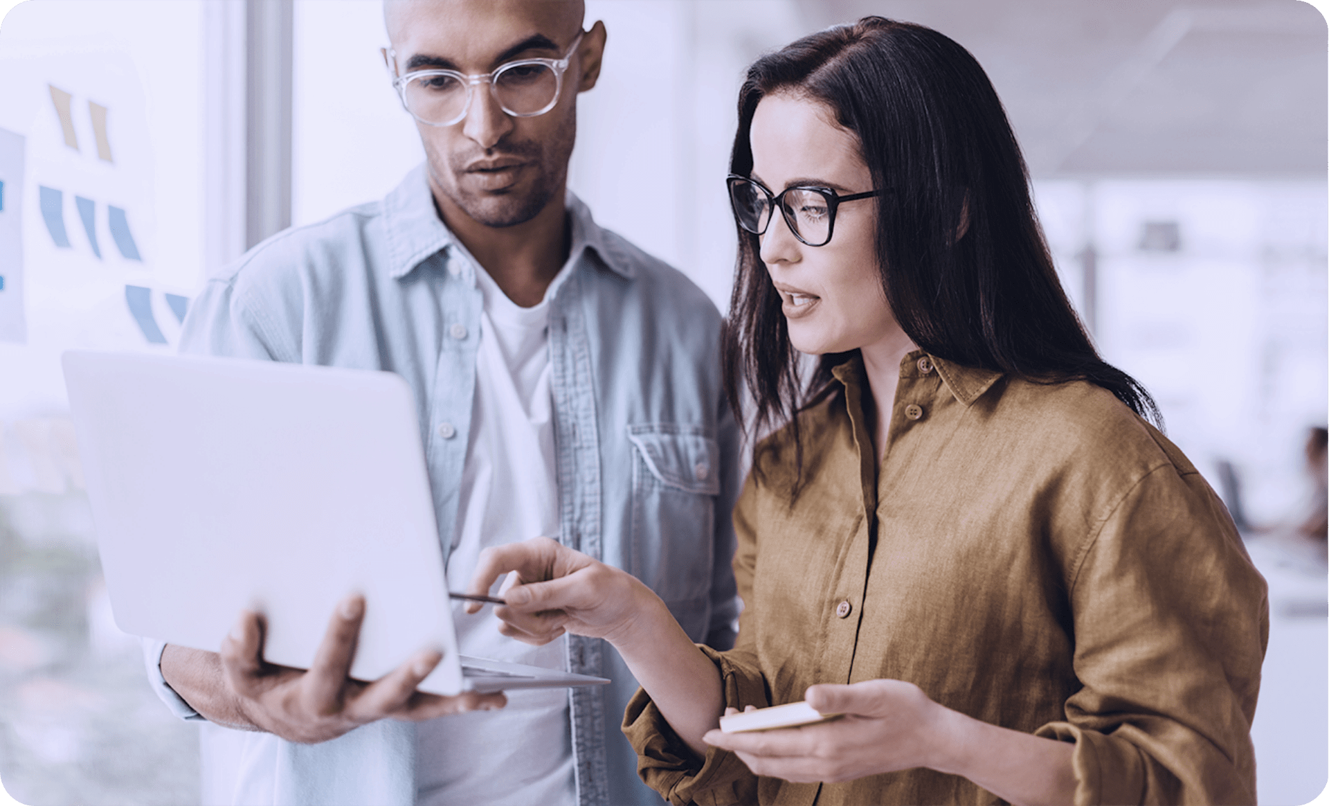 Zwei Mitarbeitende erstellen E-Learning selbst am Laptop und besprechen die Inhalte gemeinsam