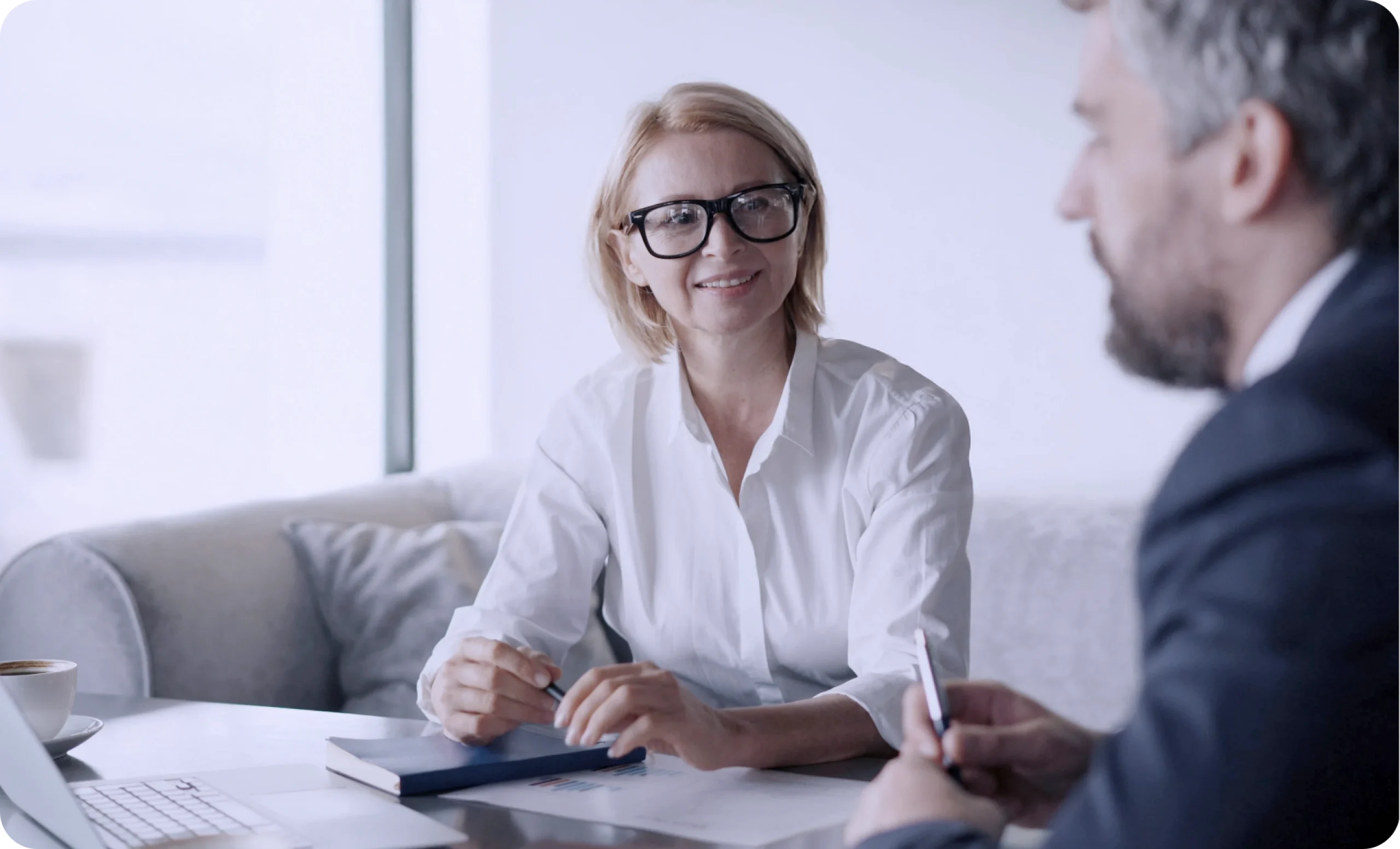 Compliance Schulung für Mitarbeiter im Unternehmen: Gespräch zwischen zwei Mitarbeitenden zur Planung von digitalen Compliance Schulungen und Weiterbildung